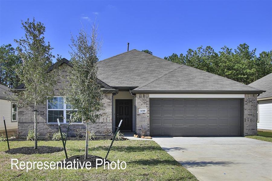 Ranch-style house with a garage and a front lawn