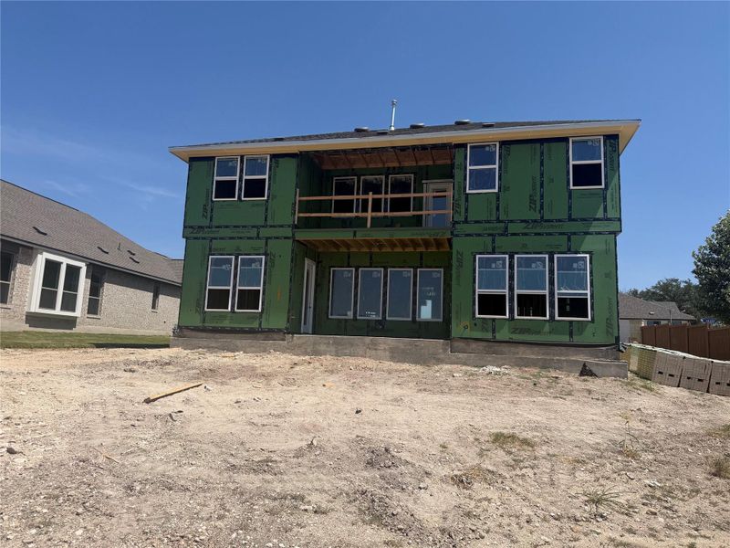 Progress continues on this two-story residential structure showcasing a modern design with an upper balcony.