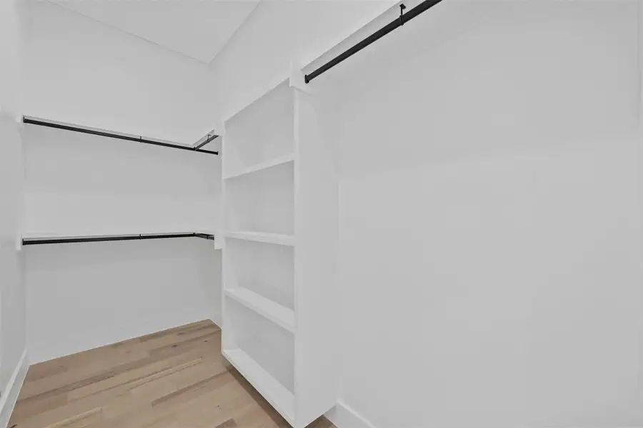 Walk in closet featuring light wood-style flooring Walk in closet featuring light wood-style flooring