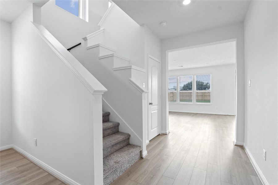 Upon entering, you find a lovely corridor showcasing custom paint, beautiful vinyl plank flooring, high ceilings, and ample lighting. Upon entering, you find a lovely corridor showcasing custom paint, beautiful vinyl plank flooring, high ceilings, and ample lighting.