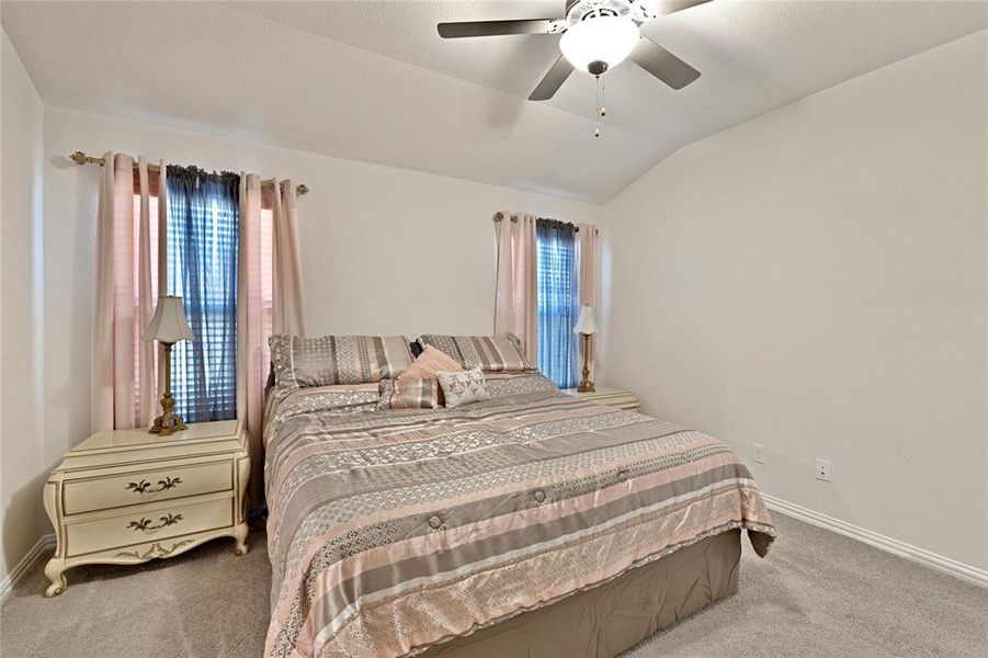 Bedroom featuring carpet flooring, ceiling fan, baseboards, and lofted ceiling