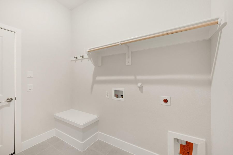 Laundry room with white walls, upper shelf with hanging rod, built-in bench, and washer hookups Laundry room with white walls, upper shelf with hanging rod, built-in bench, and washer hookups