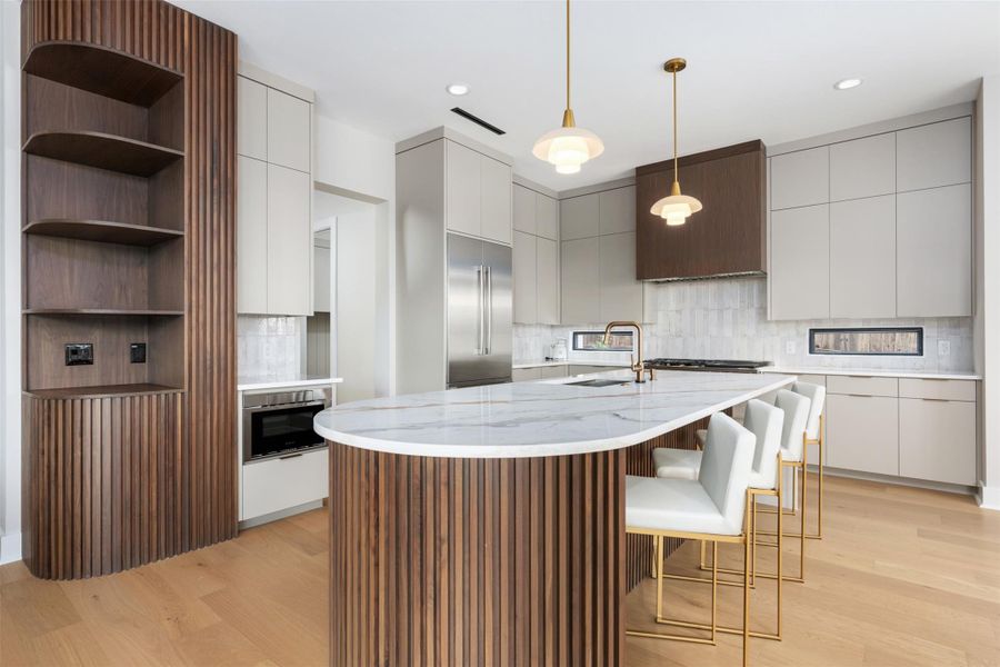 Oversized island with quartz counter, fluted wood, and 2 dishwashers. Oversized island with quartz counter, fluted wood, and 2 dishwashers.