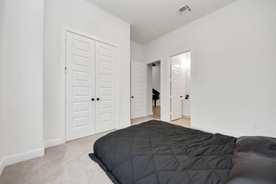 Main-level bedroom with its own attached full bath and a large closet.