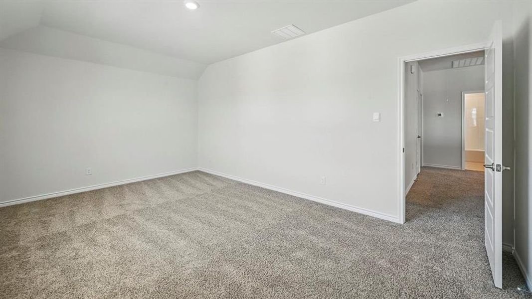 Spacious interior room featuring light gray carpet, white baseboards, and neutral wall paint