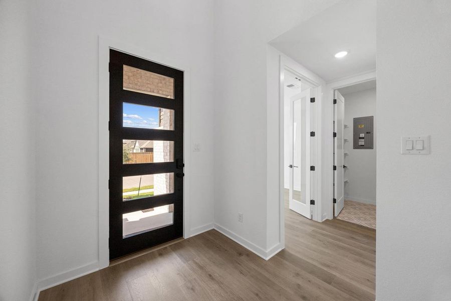 Foyer entrance featuring light wood-type flooring, electric panel, and recessed lighting Foyer entrance featuring light wood-type flooring, electric panel, and recessed lighting