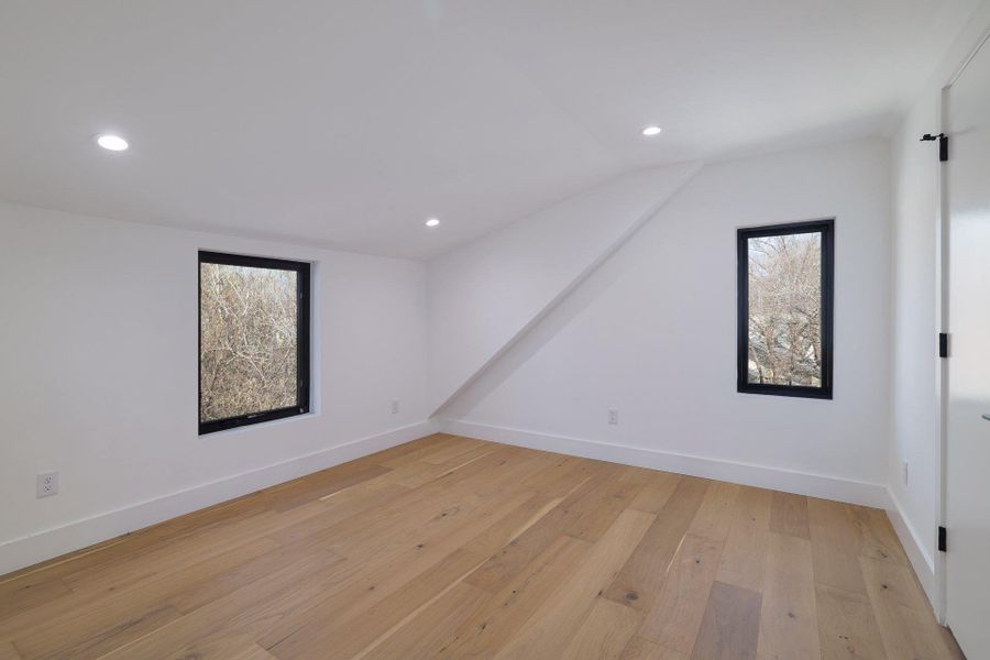 Additional living space with light wood-style flooring, recessed lighting, plenty of natural light, and lofted ceiling