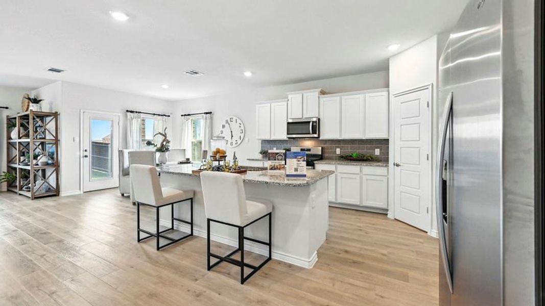 The property features an open-concept kitchen and living area with light-toned flooring throughout