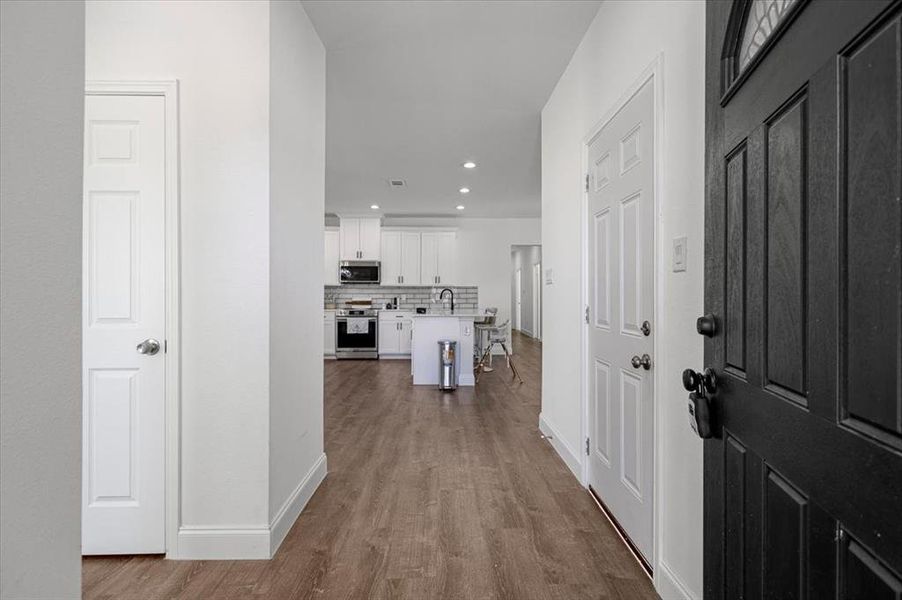 Hall with dark wood-style flooring and recessed lighting Hall with dark wood-style flooring and recessed lighting