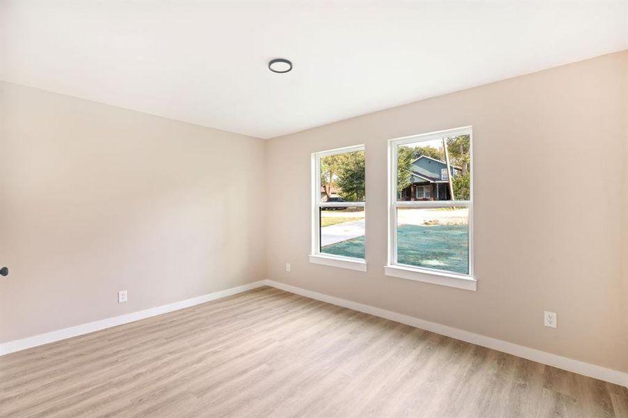Unfurnished room featuring light wood finished floors and baseboards