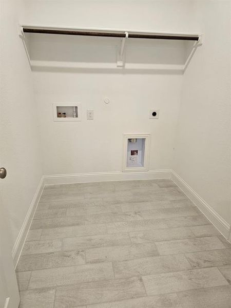 Washroom featuring gas dryer hookup, electric dryer hookup, washer hookup, and light wood-type flooring