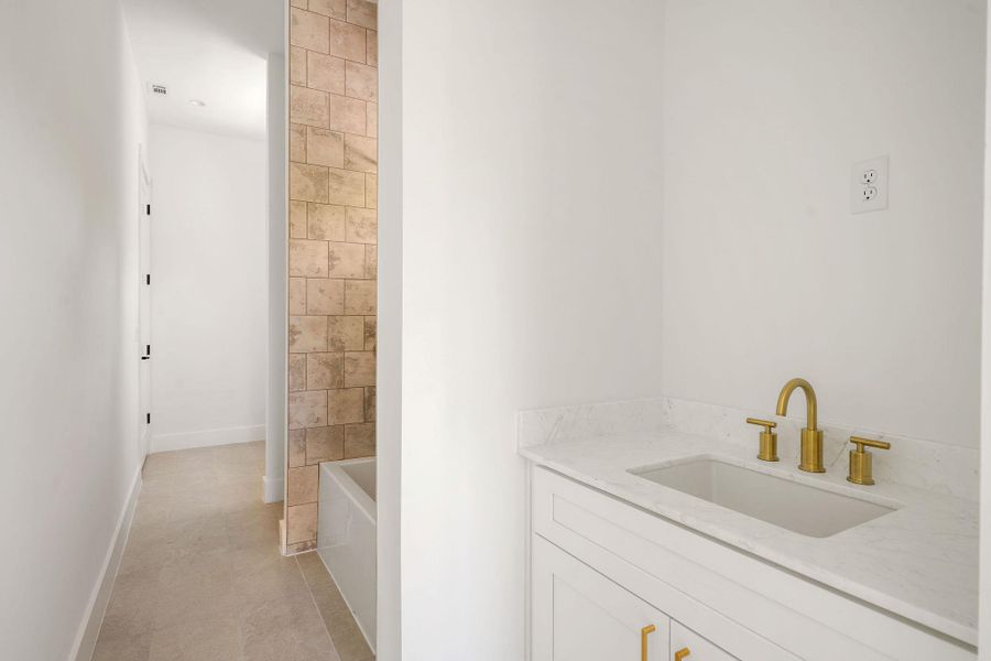 Bathroom with tile patterned floors, vanity, and baseboards