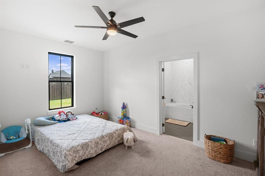 Bedroom with carpet floors, ensuite bath, ceiling fan, and baseboards Bedroom with carpet floors, ensuite bath, ceiling fan, and baseboards