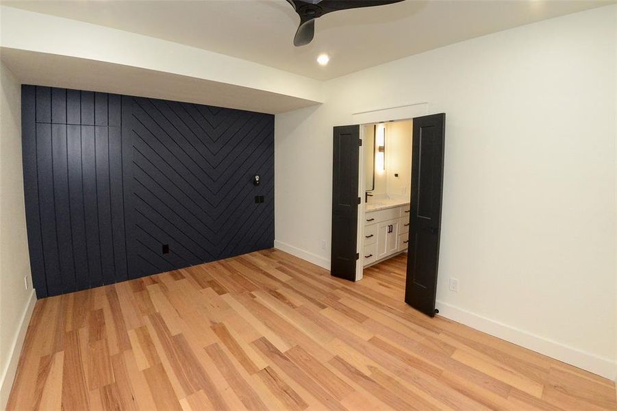 Unfurnished bedroom with light wood finished floors, ceiling fan, recessed lighting, and connected bathroom