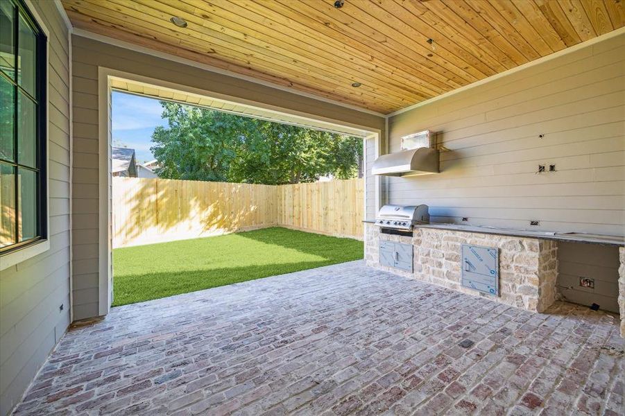 Outdoor covered patio with outdoor kitchen. Estimated completion date of construction - January 15, 2025.