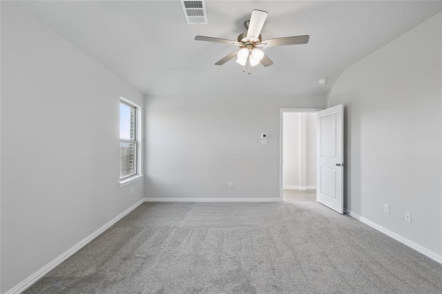 Carpeted empty room with vaulted ceiling and ceiling fan Carpeted empty room with vaulted ceiling and ceiling fan