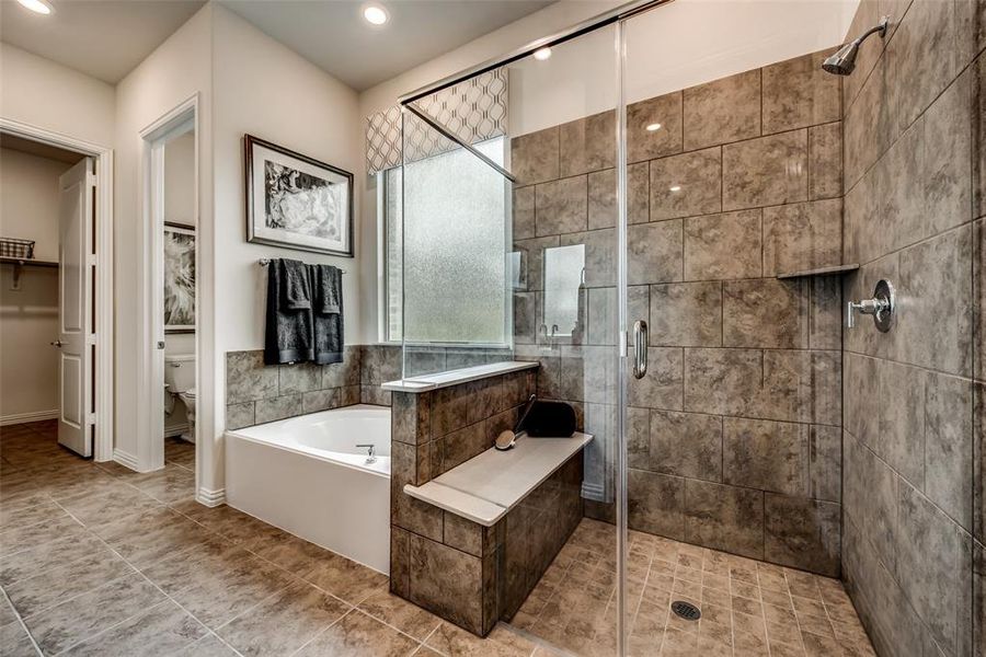 Full bath with a shower stall, a spacious closet, a bath, tile patterned floors, and recessed lighting