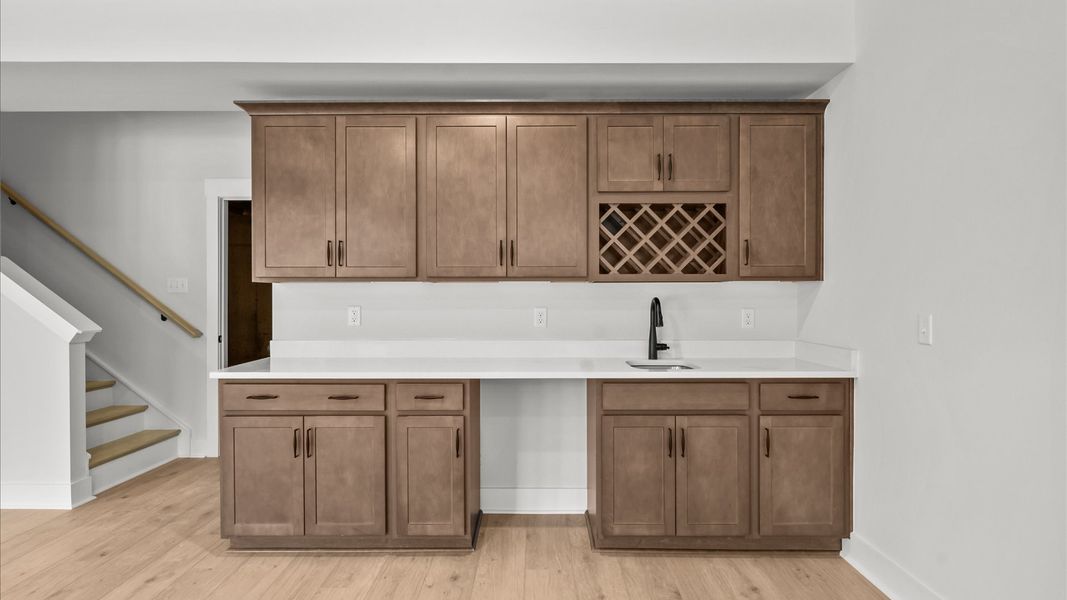 A versatile hardwood basement complete with a walk-in closet and entertainment-ready wet bar