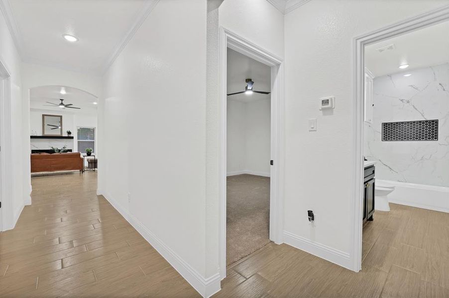 Hallway featuring light wood-style floors and ornamental molding