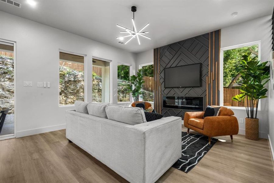 Living room featuring a fireplace, a chandelier, and light wood finished floors