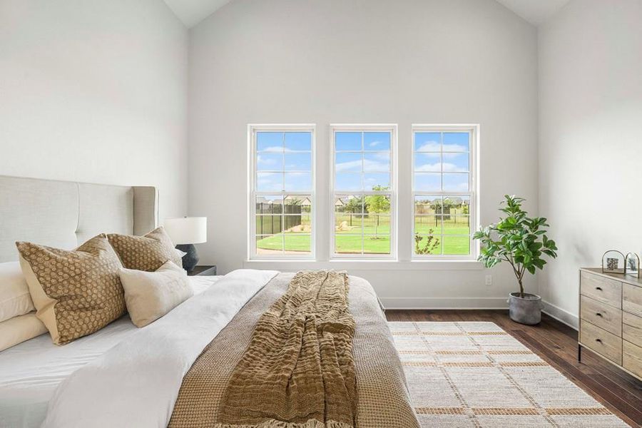 Virtually staged Primary Bedroom featuring multiple windows, engineered wood flooring, and high vaulted ceiling Virtually staged Primary Bedroom featuring multiple windows, engineered wood flooring, and high vaulted ceiling
