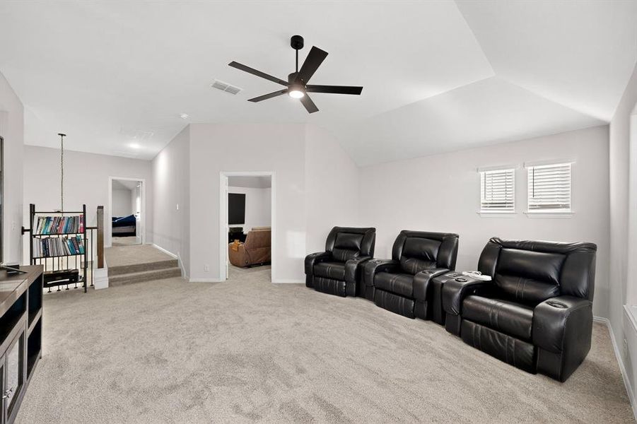 Cinema featuring light colored carpet and ceiling fan Cinema featuring light colored carpet and ceiling fan
