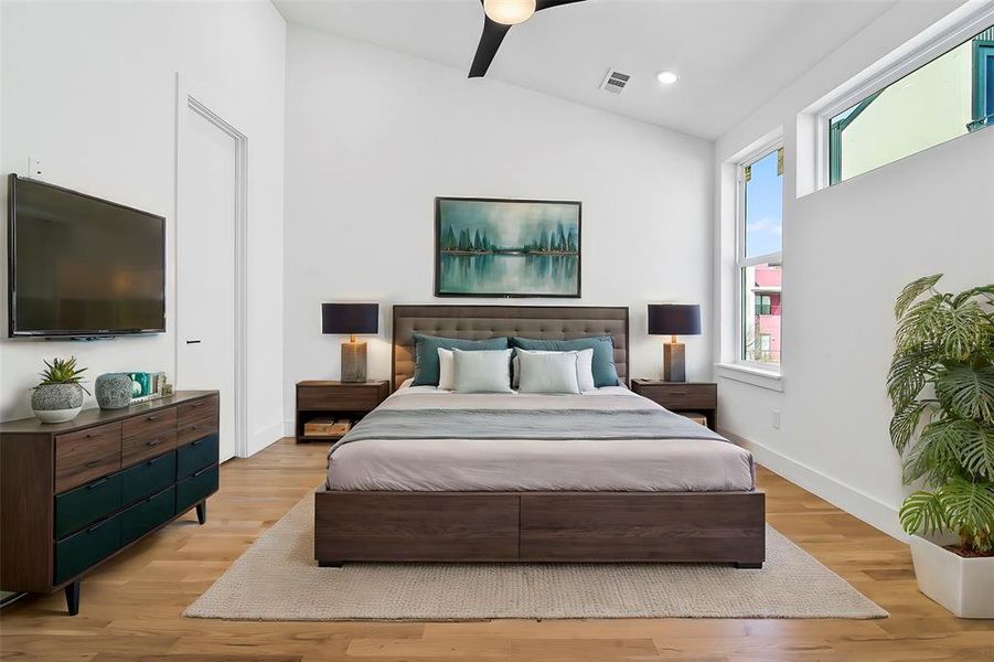 Bedroom with vaulted ceiling, light hardwood flooring, and ceiling fan