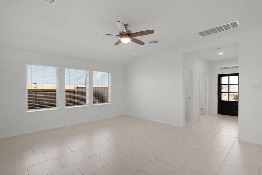 Unfurnished room with ceiling fan, light tile patterned flooring, and vaulted ceiling