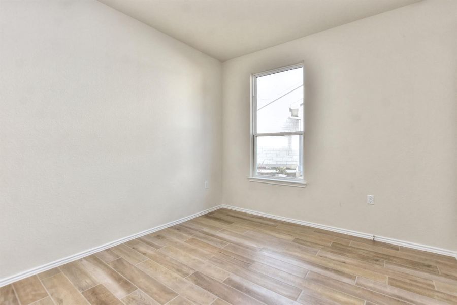 Spare room with baseboards and light wood finished floors