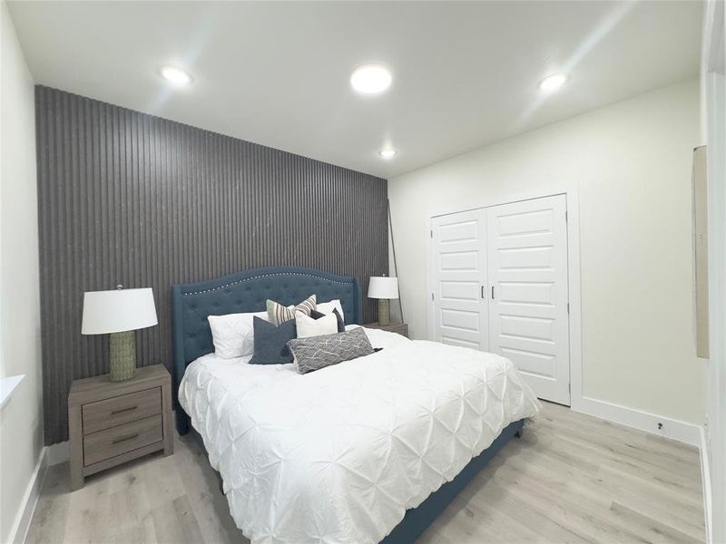 Bedroom with light hardwood / wood-style floors and a closet