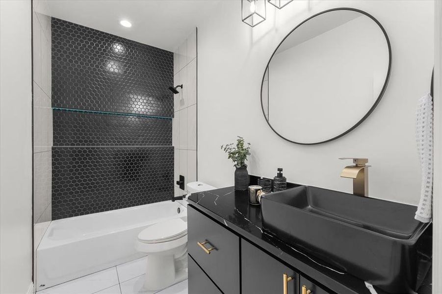 Bathroom featuring bathtub / shower combination, vanity, and light tile patterned flooring