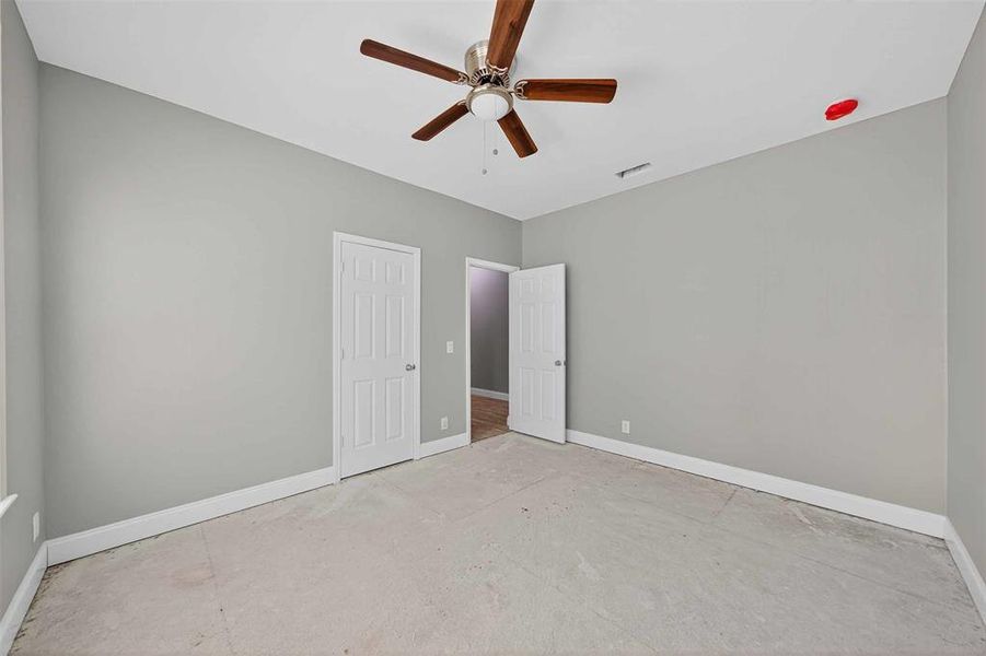 Unfurnished bedroom with ceiling fan and a closet