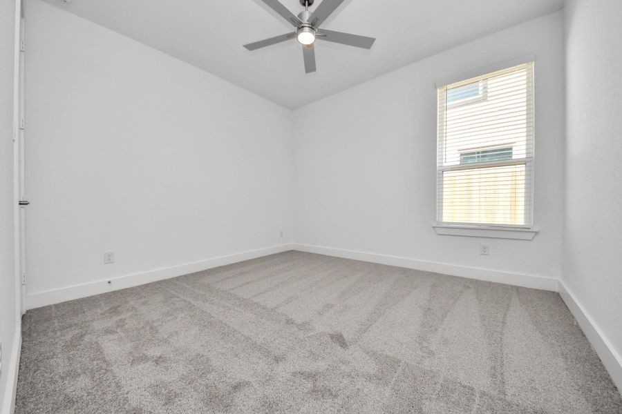 Secondary bedroom features plush carpeting, large windows that let in plenty of natural light, bright paint, and spacious closets.