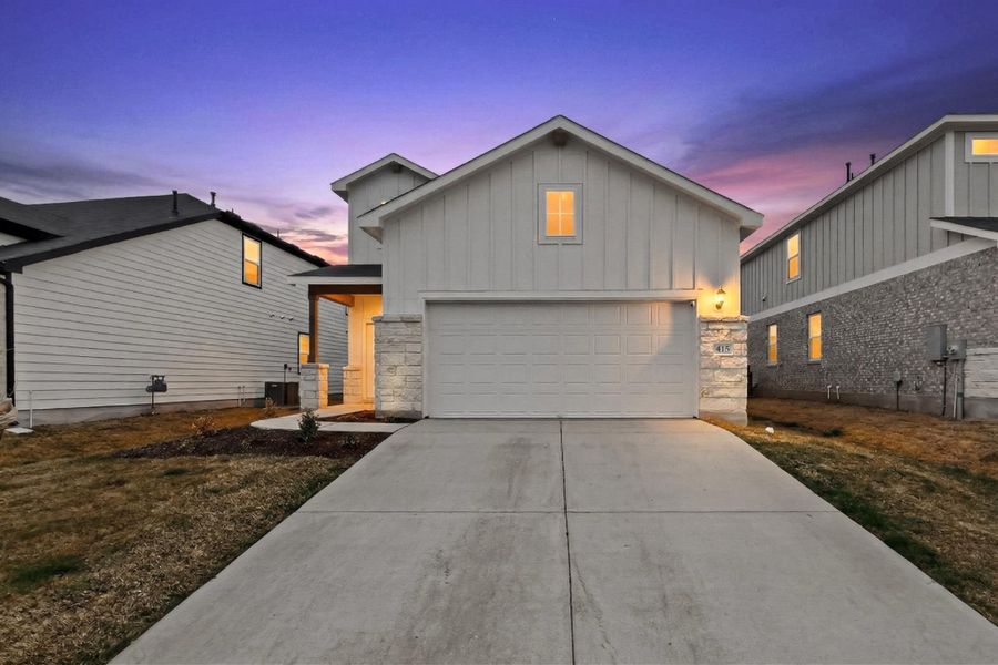 View of front of property with stone siding, board and batten siding, and concrete driveway