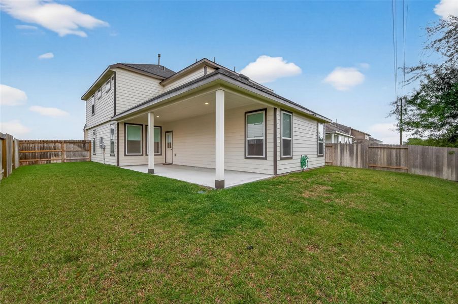 The spacious backyard features a lawn of green grass, creating an open area for outdoor activities and gatherings.