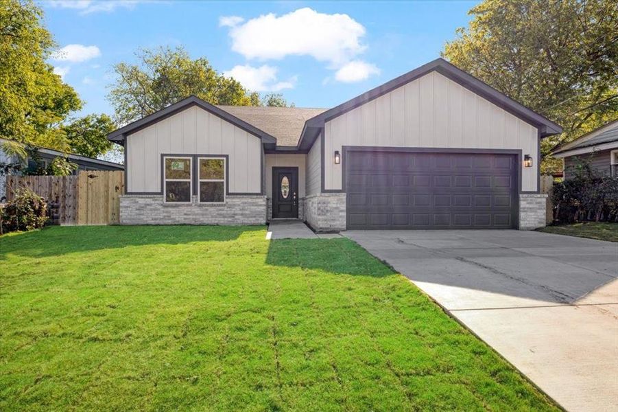 View of front of home with a front lawn and a garage