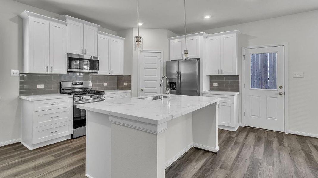 Modern kitchen featuring white shaker cabinets, quartz countertops, stainless steel appliances, and a large island with pendant lighting. Modern kitchen featuring white shaker cabinets, quartz countertops, stainless steel appliances, and a large island with pendant lighting.