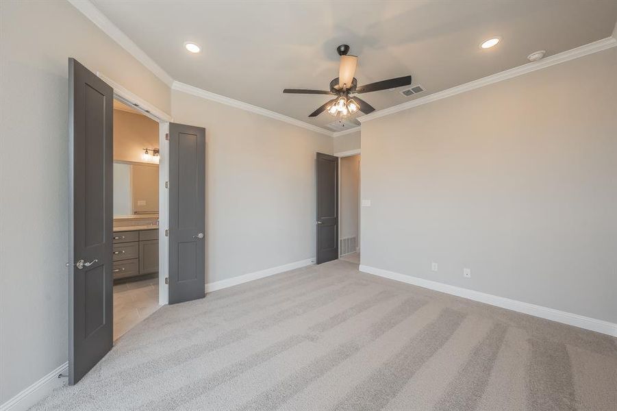 Carpeted room featuring a ceiling fan with light kit, recessed lighting, and crown molding