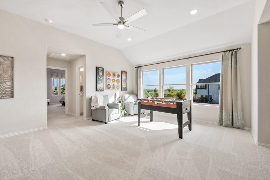 Bonus room with foosball table, vaulted ceiling, ceiling fan, and large windows with outdoor views Bonus room with foosball table, vaulted ceiling, ceiling fan, and large windows with outdoor views