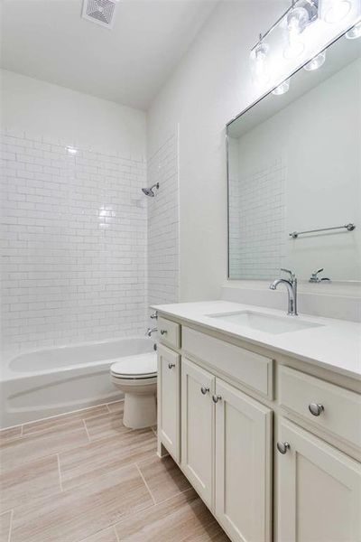 Full bathroom with vanity, toilet, and tiled shower / bath