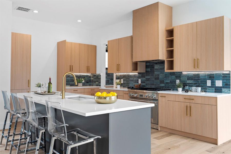 The property features a modern kitchen with light wood cabinetry, a dark blue tiled backsplash, and light countertops