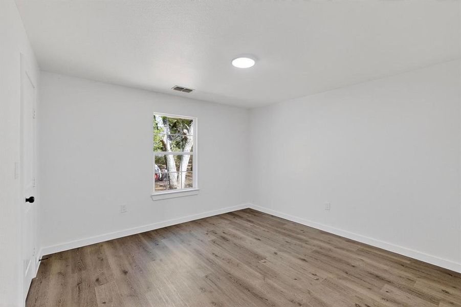 Unfurnished room featuring light wood finished floors and baseboards