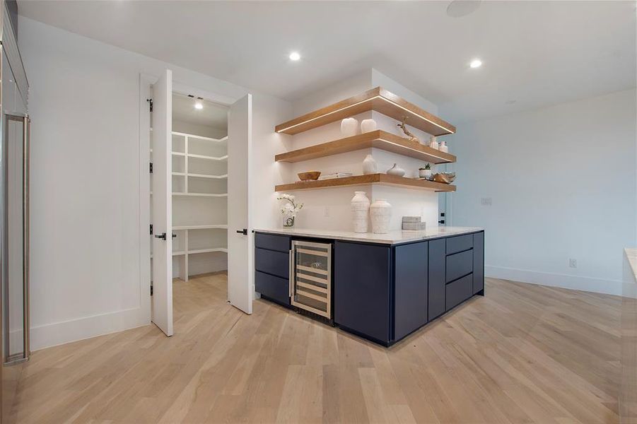 Bar with light hardwood / wood-style flooring and wine cooler