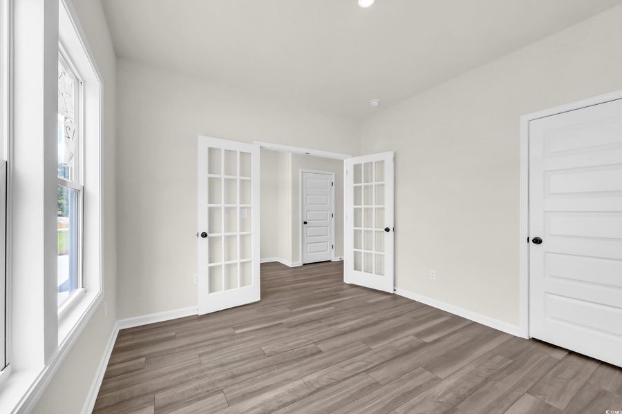 Empty room with french doors and wood finished floors