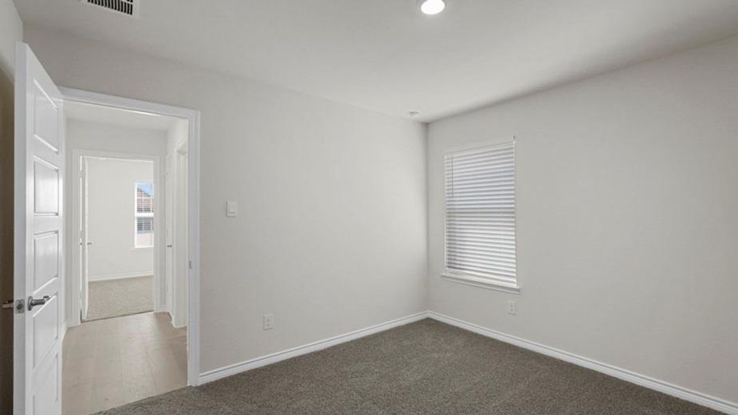 Carpeted room with recessed lighting and a window featuring horizontal blinds