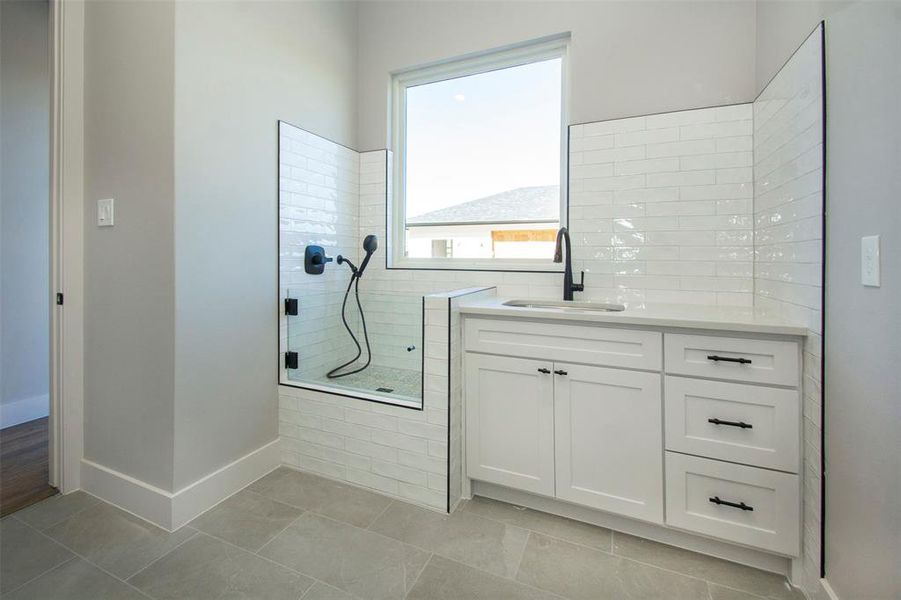 Bathroom with vanity, tile patterned floors, and an enclosed shower