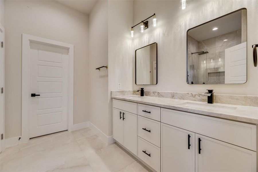 Full bathroom with a stall shower, double vanity, and light tile patterned flooring Full bathroom with a stall shower, double vanity, and light tile patterned flooring