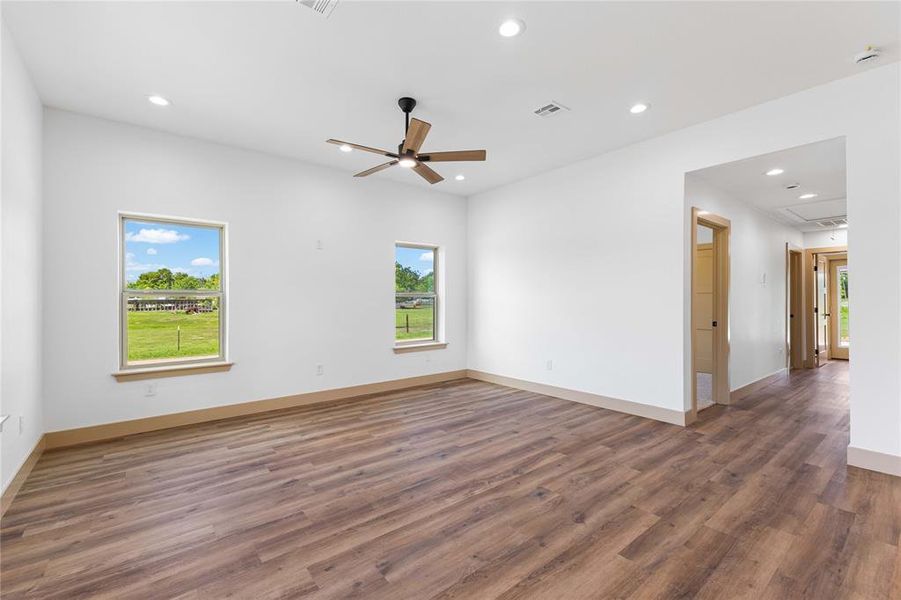 Unfurnished room featuring dark wood finished floors, healthy amount of natural light, recessed lighting, and a ceiling fan