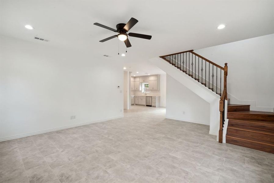 Unfurnished living room featuring ceiling fan