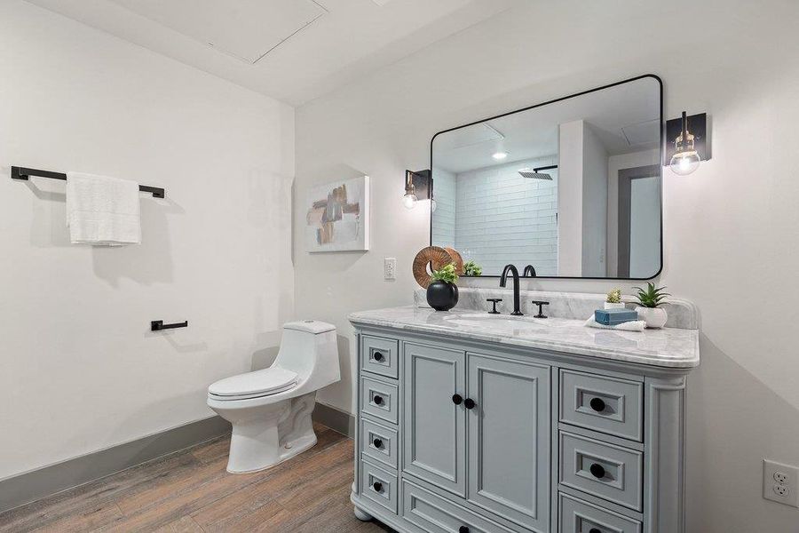 Full bath featuring vanity, a shower, and dark wood finished floors